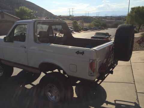1995 Ford Bronco - This lifted 1995 Ford Bronco has its soft top removed, revealing the interior and a spare tire mounted on the back.