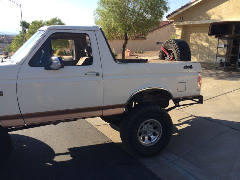 1995 Ford Bronco - This lifted 1992 Ford Bronco is shown from the side with a spare tire mounted in the bed.