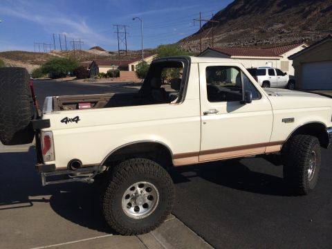 1995 Ford Bronco - This 1995 Ford Bronco is shown from the side with its top removed, parked in a suburban neighborhood.