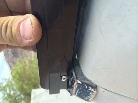 1995 Ford Bronco - Detail of the soft top attachment mechanism on a white vehicle, with a hand visible.