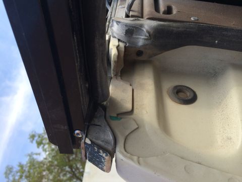 1995 Ford Bronco - Close-up view of a soft top mounting bracket on a vehicle, showing wear and tear.