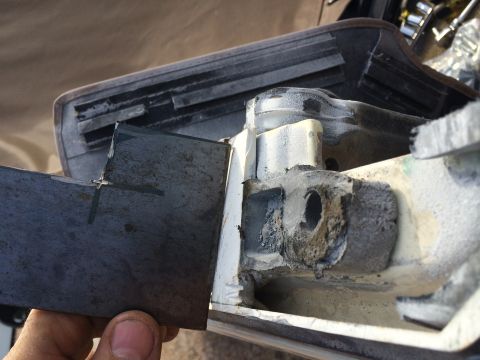 1995 Ford Bronco - Close-up of a metal bracket being held, with visible wear and tear on surrounding parts.