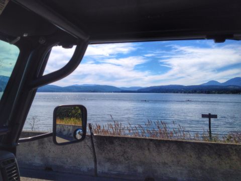 2005 Jeep Wrangler - The view from inside a 2005 Jeep Wrangler shows a lake with distant mountains under a cloudy sky.