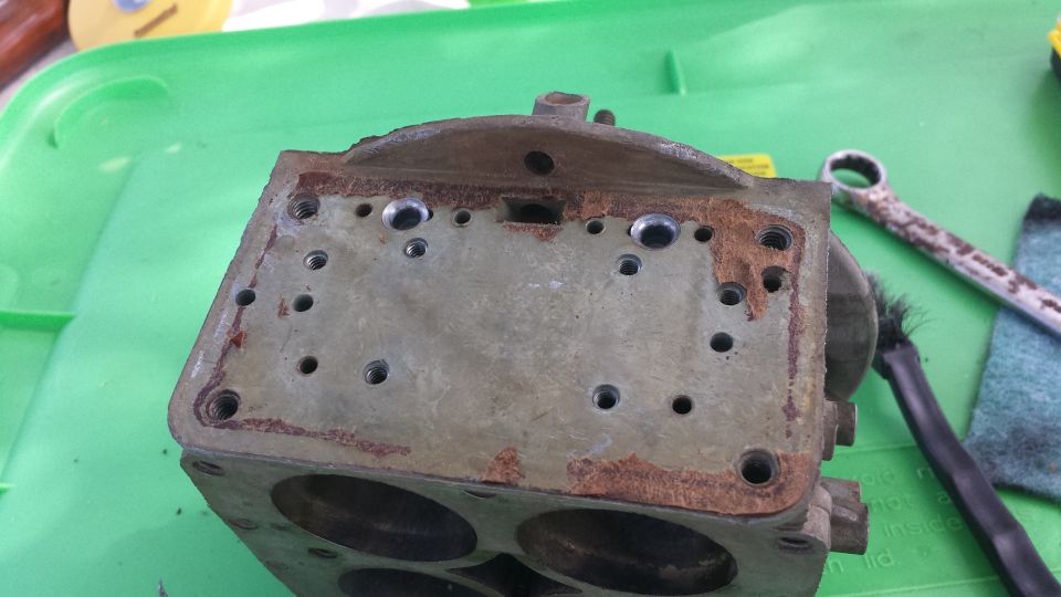 carburetor base with bolt holes and rust