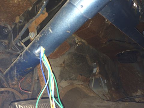1964 Ford Fairlane - The interior of a vehicle shows a rusty dashboard and a blue steering column with loose wiring.
