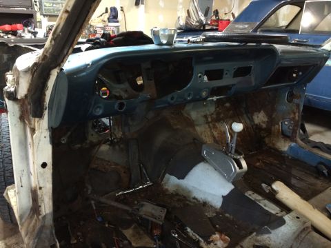 1964 Ford Fairlane - Interior view of a 1964 Ford Fairlane undergoing restoration, with the dashboard removed and floor showing significant rust.