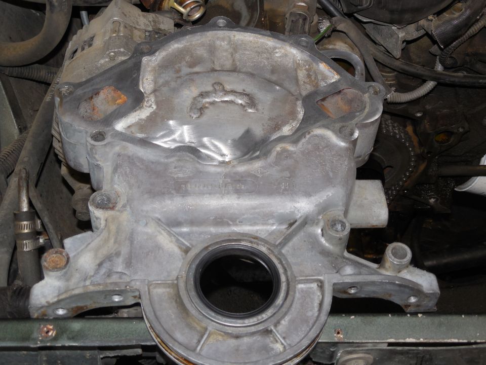 Engine timing cover with a black seal installed in the center opening