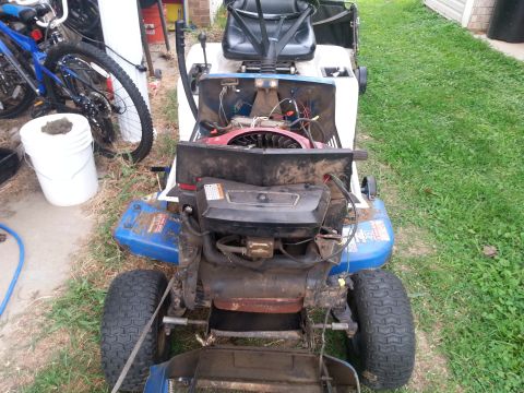 2002 Ford Expedition - A riding lawn mower is shown from the rear with its engine compartment open for maintenance.