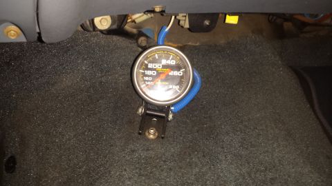 1996 Ford Bronco - An aftermarket gauge is installed on the floor of a vehicle.