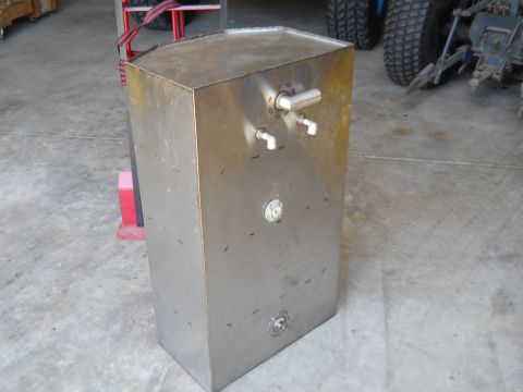 1992 Ford Bronco - A metal fuel tank with visible fittings and a gauge is shown in a garage setting.