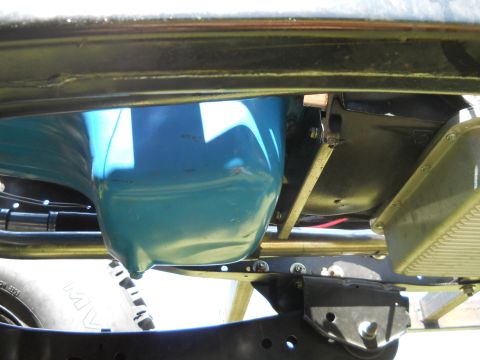 1992 Ford Bronco - Close-up view of the vehicle's undercarriage, focusing on the oil pan and suspension parts.
