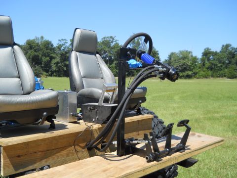 1992 Ford Bronco - A custom-built vehicle interior with dual seating and complex controls is shown outdoors.