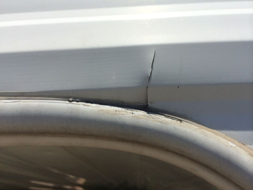 White panel with a vertical crack above a curved white trim piece