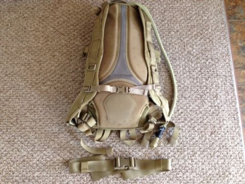 2005 Audi S4 - A tan tactical backpack with its hydration tube and waist strap detached is shown from the back on a carpeted surface.