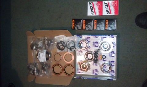 1990 Ford Bronco - A collection of automotive bearings and seals are laid out on a dark surface.