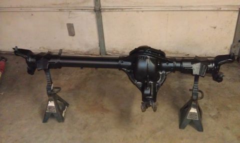 1990 Ford Bronco - A black rear axle assembly is supported by jack stands in a garage setting.