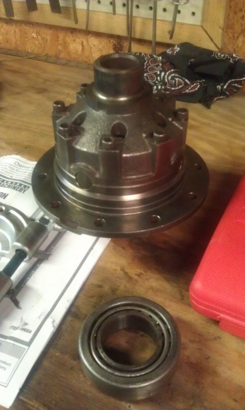 1990 Ford Bronco - A differential carrier and bearing are on a workbench, suggesting automotive repair or parts.