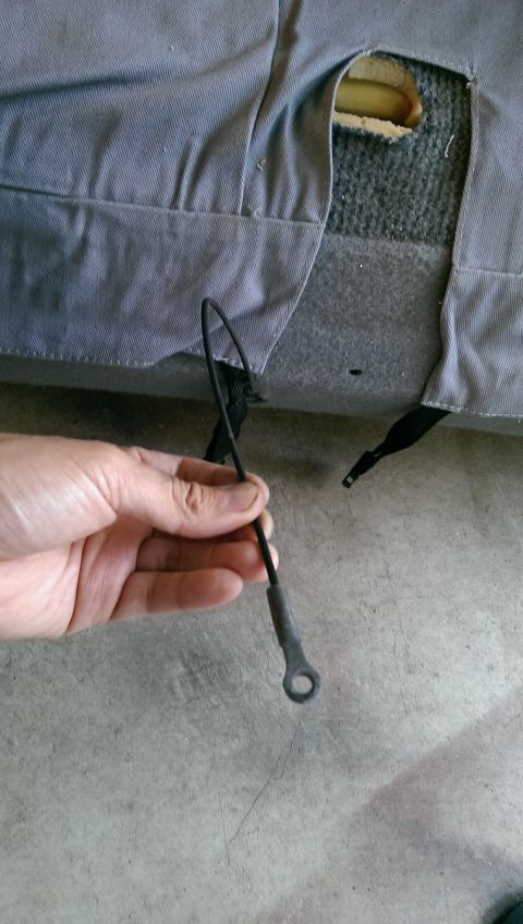1996 Ford F-150 - A hand holds a detached cable from torn seat upholstery, revealing the seat cushion underneath.