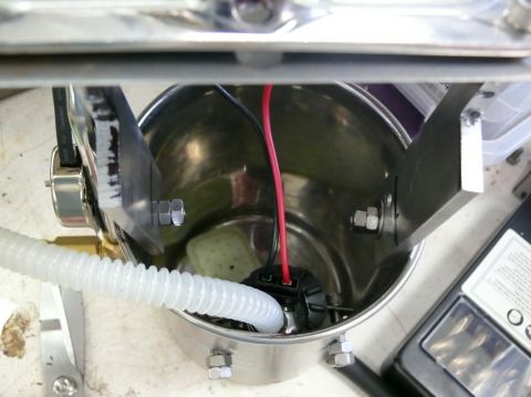 Close-up of a fuel pump assembly with a white hose and red/black wires