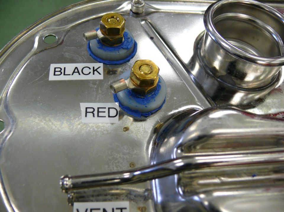 Close-up of a fuel pump assembly with labels for 'BLACK' and 'RED' connections