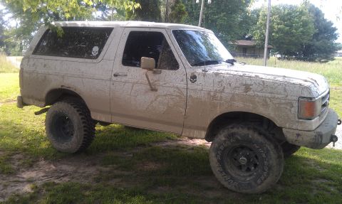 1990 Ford Bronco - This 1990 Ford Bronco is covered in mud, suggesting recent off-road use.