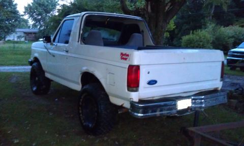 1990 Ford Bronco - This lifted Ford Bronco is parked outdoors, showing its rear and side profile with aftermarket wheels.