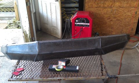 1990 Ford Bronco - Custom steel bumper fabricated in a workshop setting, with welding equipment visible.
