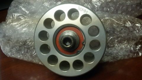 2003 Ford Crown Victoria - round aluminum pulley engraved "90MM" with a drilled face and orange-sealed center bearing lies on bubble wrap.