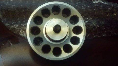 2003 Ford Crown Victoria - drilled aluminum pulley with a raised stepped center hub sits on a dark surface over bubble wrap.