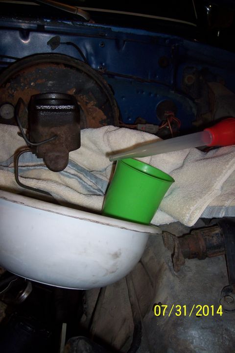 1978 Ford Bronco - Brake master cylinder service in progress, with fluid being collected.