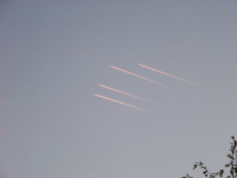 1995 Mercury Grand Marquis - Contrails streak across the sky, suggesting aircraft activity.