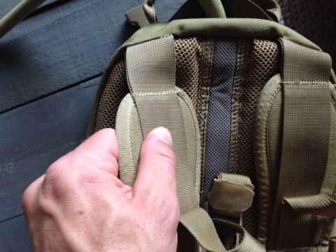 2005 Audi S4 - Close-up of a hand on a tan backpack strap, showing mesh padding and webbing details.