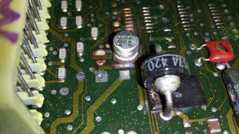 1992 Ford Bronco - A close-up view of a damaged electronic control unit (ECU) circuit board shows burnt components and solder points.