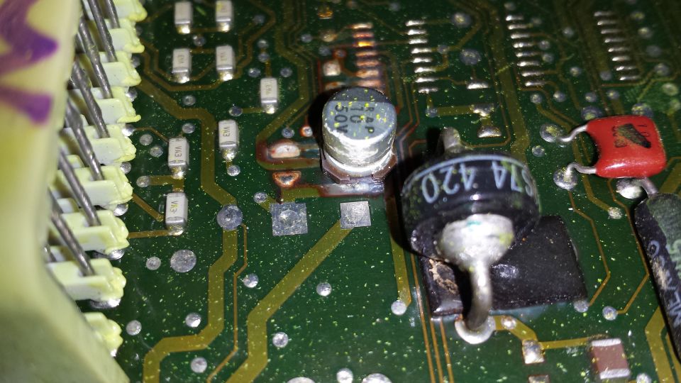 Close-up of a burned ECU circuit board with visible components and solder