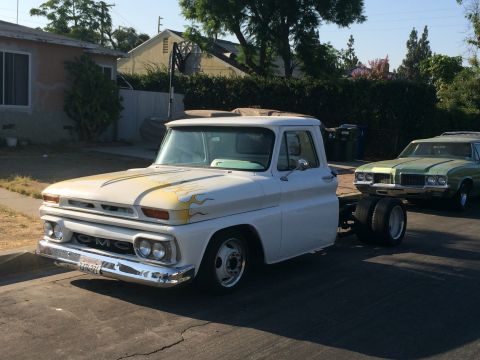 1968 Ford Mustang - A white GMC pickup truck with flame decals is parked on a residential street, with another car behind it.