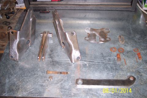 1978 Ford Bronco - Various metal brake parts and hardware are displayed on a workbench, possibly for repair or restoration.