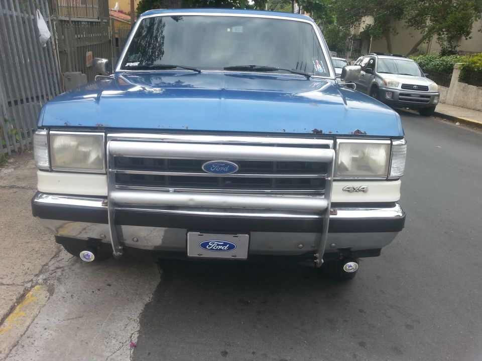 Blue 1990 Ford Bronco front view with chrome grille and bumper