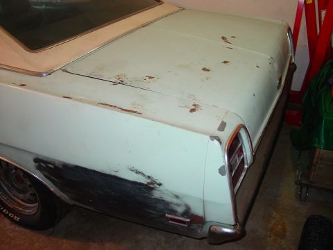 1969 Ford Torino - The rear of a car shows signs of rust and bodywork, with a tail light and bumper visible.