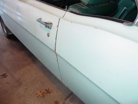 1969 Ford Torino - Close-up of a car's side door, showing the handle, a portion of the interior, and the two-tone paint scheme.