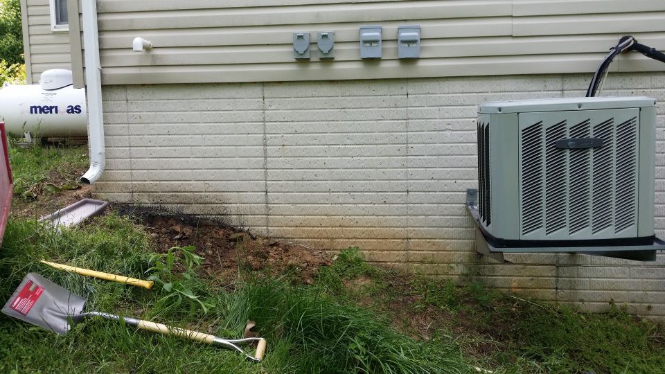 Air conditioning unit mounted on a wall next to a propane tank