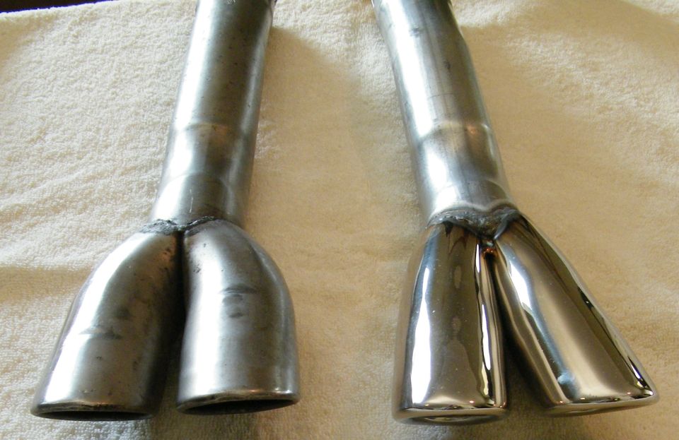 Two chrome dual exhaust tips, one polished, one raw metal, on a towel