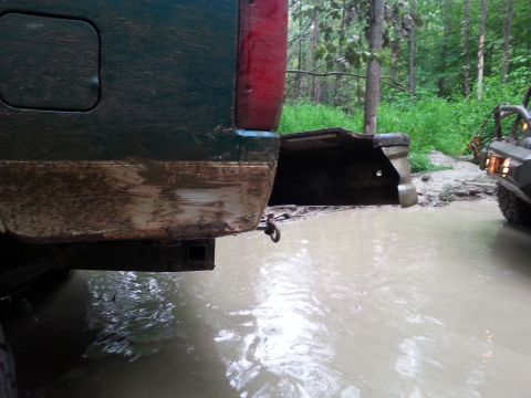 1996 Ford Bronco - A green SUV is stuck in muddy water, with another off-road vehicle visible in the background.