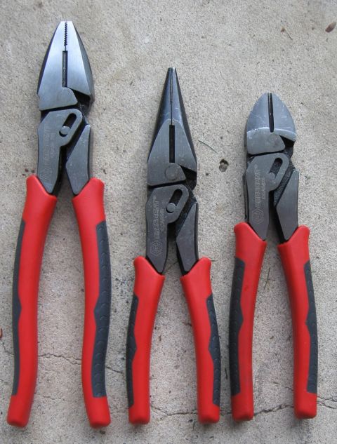 2000 Ford Crown Victoria - A collection of three pliers, each red and gray handles, is displayed on a textured concrete background.