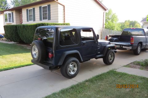 2000 Jeep Wrangler - 2000 Jeep Wrangler parked in front of a house with a pickup truck behind it.