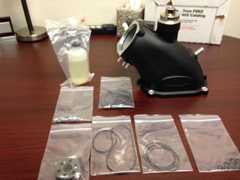 2010 Dodge Challenger - Supercharger intake part and gasket kit laid out on a desk.