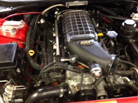 2010 Dodge Challenger - Close-up view of an engine bay a prominent supercharger and associated components.