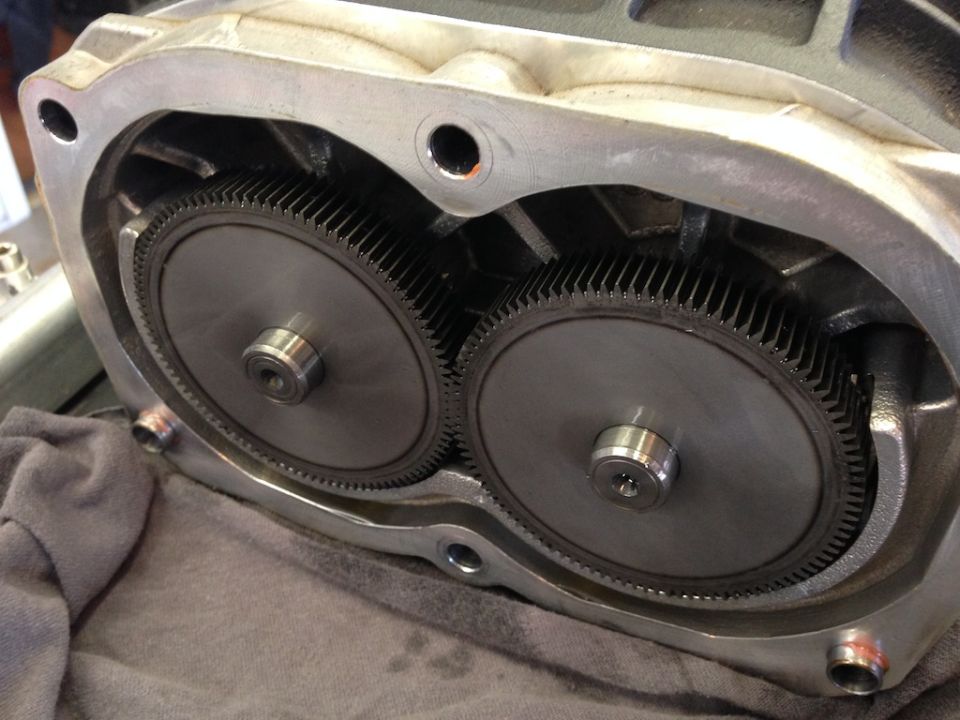 Close-up of supercharger rotors and gears inside housing