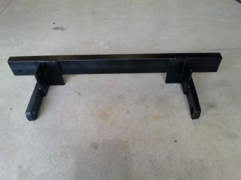 1996 Ford Bronco - A black metal bracket with two mounting points on each side is shown against a concrete floor.