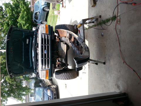 1996 Ford Bronco - This Ford truck is undergoing repairs with its front bumper removed and hood open, revealing the engine bay.
