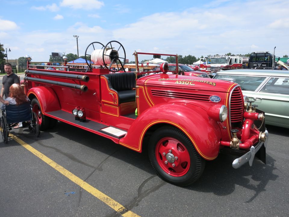 Restored red antique Ford fire engine on display at car show